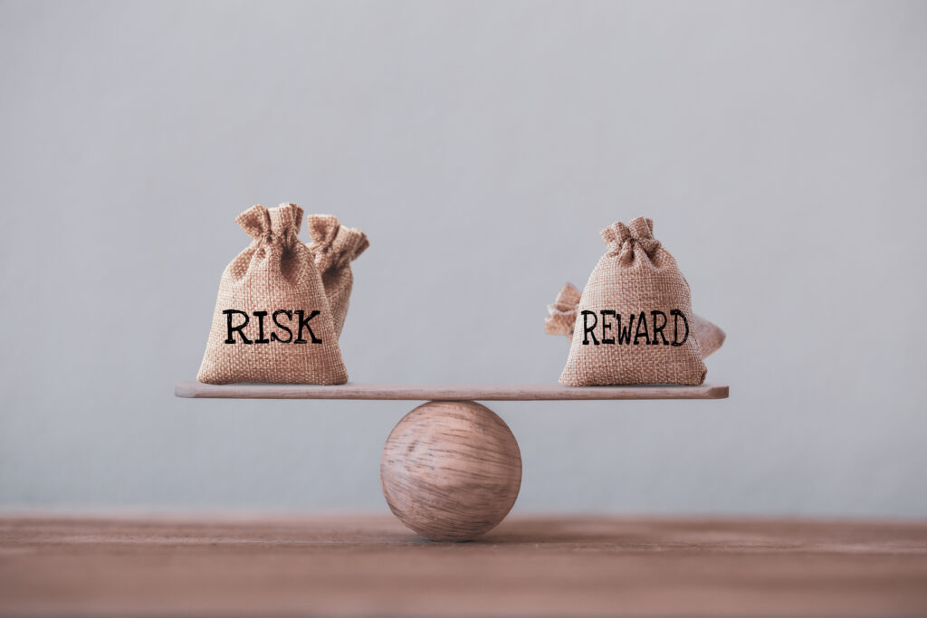 Risk and reward bags on a basic balance scale in equal position on wood table.