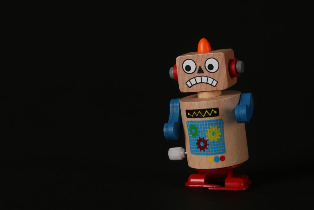 A cheap-looking plastic toy robot with a silly expression on its face