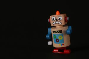 A cheap-looking plastic toy robot with a silly expression on its face